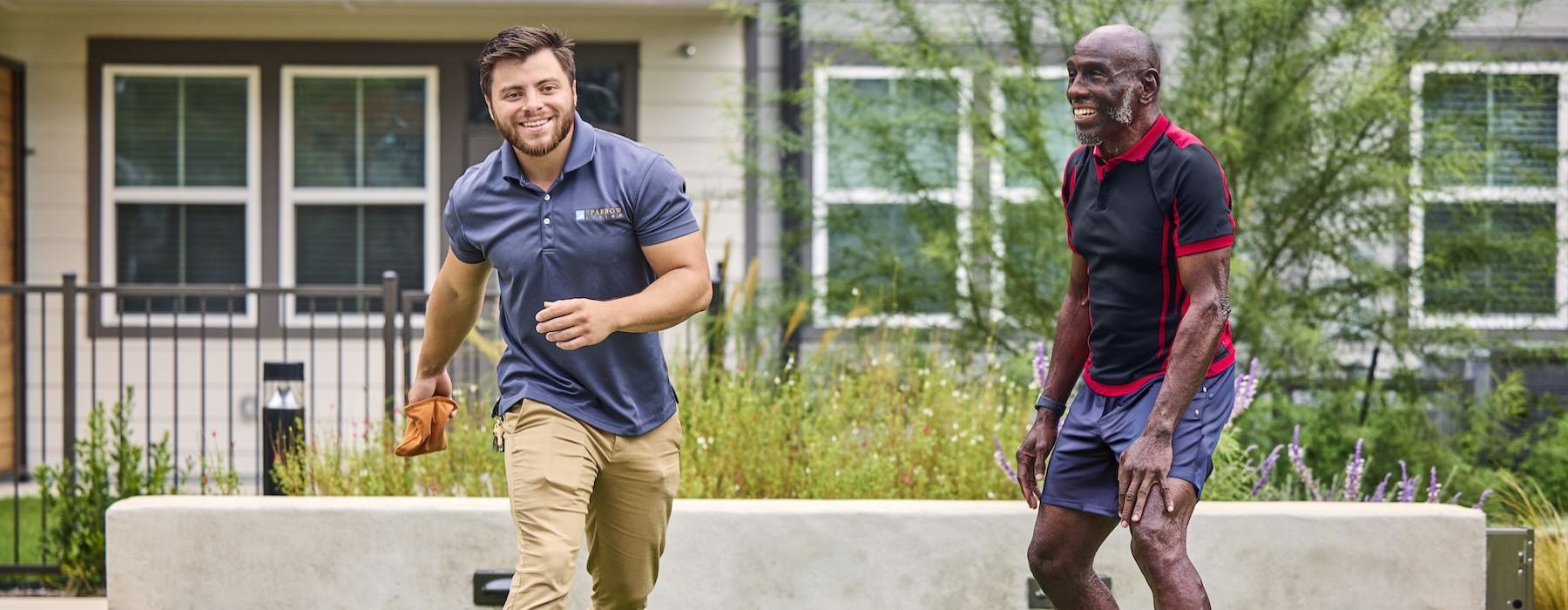 a couple of men playing cornhole